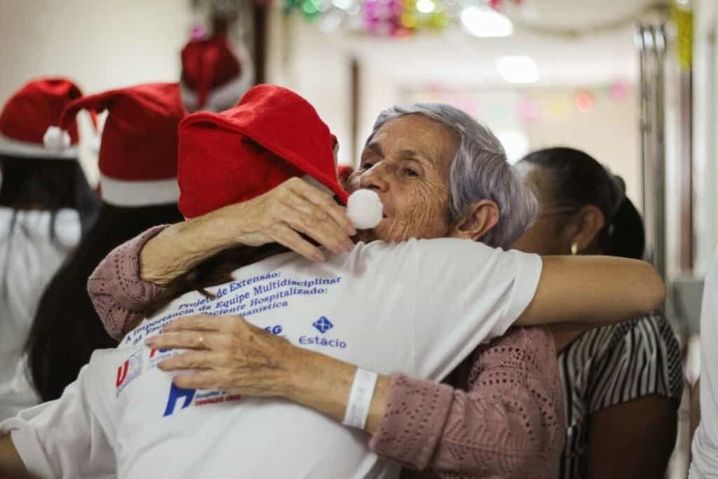 Age care nurse hugging an elderly woman she takes care of
